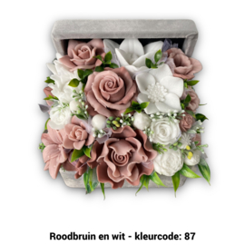 Zeepbloemen in middelgrote kist bedekt met stof
