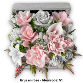 Zeepbloemen in middelgrote kist bedekt met stof