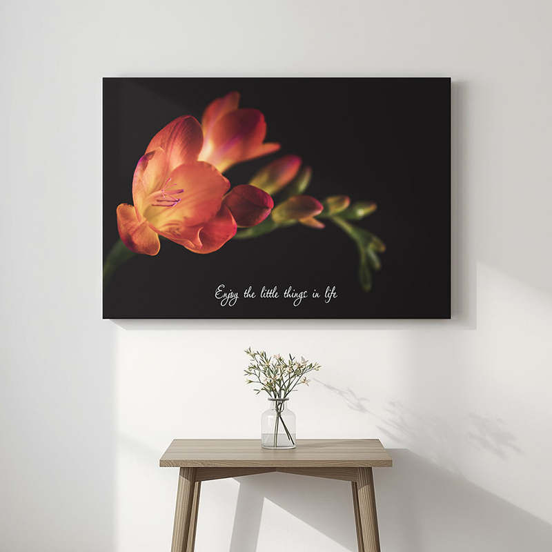 Inspirerende tekst op canvas met bloemen aan de muur