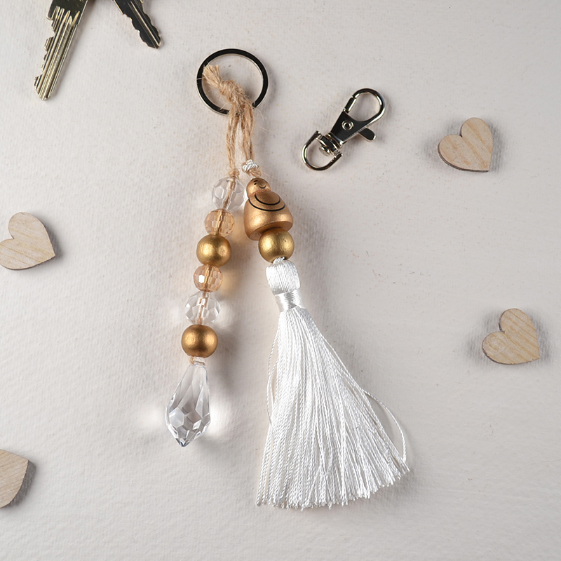 Sleutelhanger met boeddha, kristal en kwastje – wit & goud
