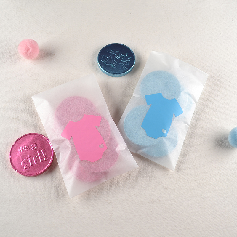 Pergamijn zakje met blauwe of roze geboortemunten en minirompertje – lief geboorte traktatiecadeautje