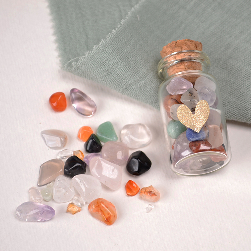 Klein glazen potje met edelsteentjes, mineralen en een goudkleurig hartje