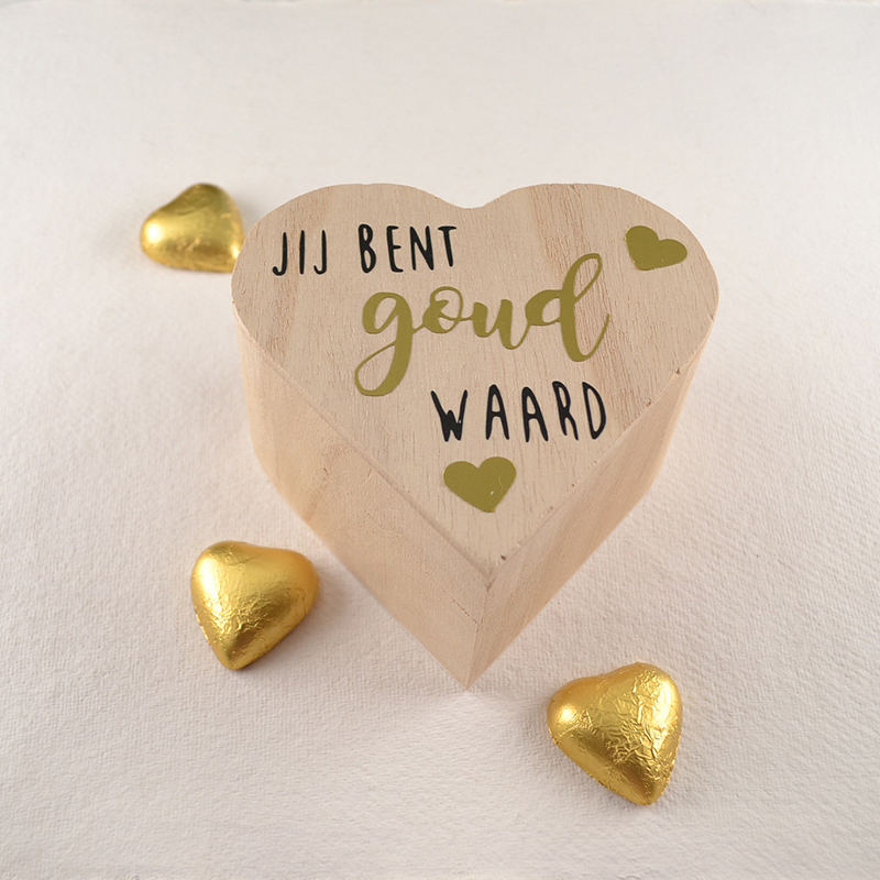 Houten hartvormig doosje met zwarte en gouden tekst 'Jij bent goud waard', omringd door chocoladehartjes