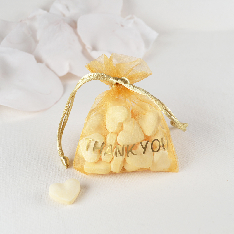 Goudkleurig organza zakje met witte snoephartjes en gouden “THANK YOU” – luxe bedankje met een knipoog