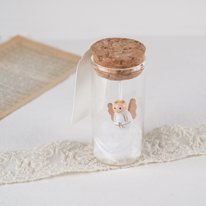 Miniatuur engeltje in glazen potje met kurkdeksel, witte veertjes en label voor persoonlijke tekst