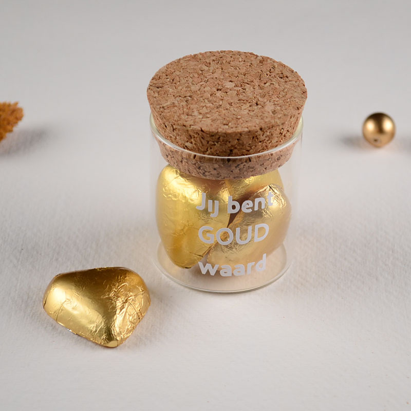Glazen potje met kurk gevuld met gouden chocoladehartjes en tekst 'Jij bent goud waard' op het glas