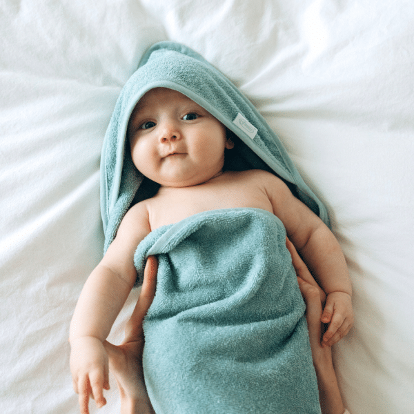 Baby in een badhanddoek na het badritueel