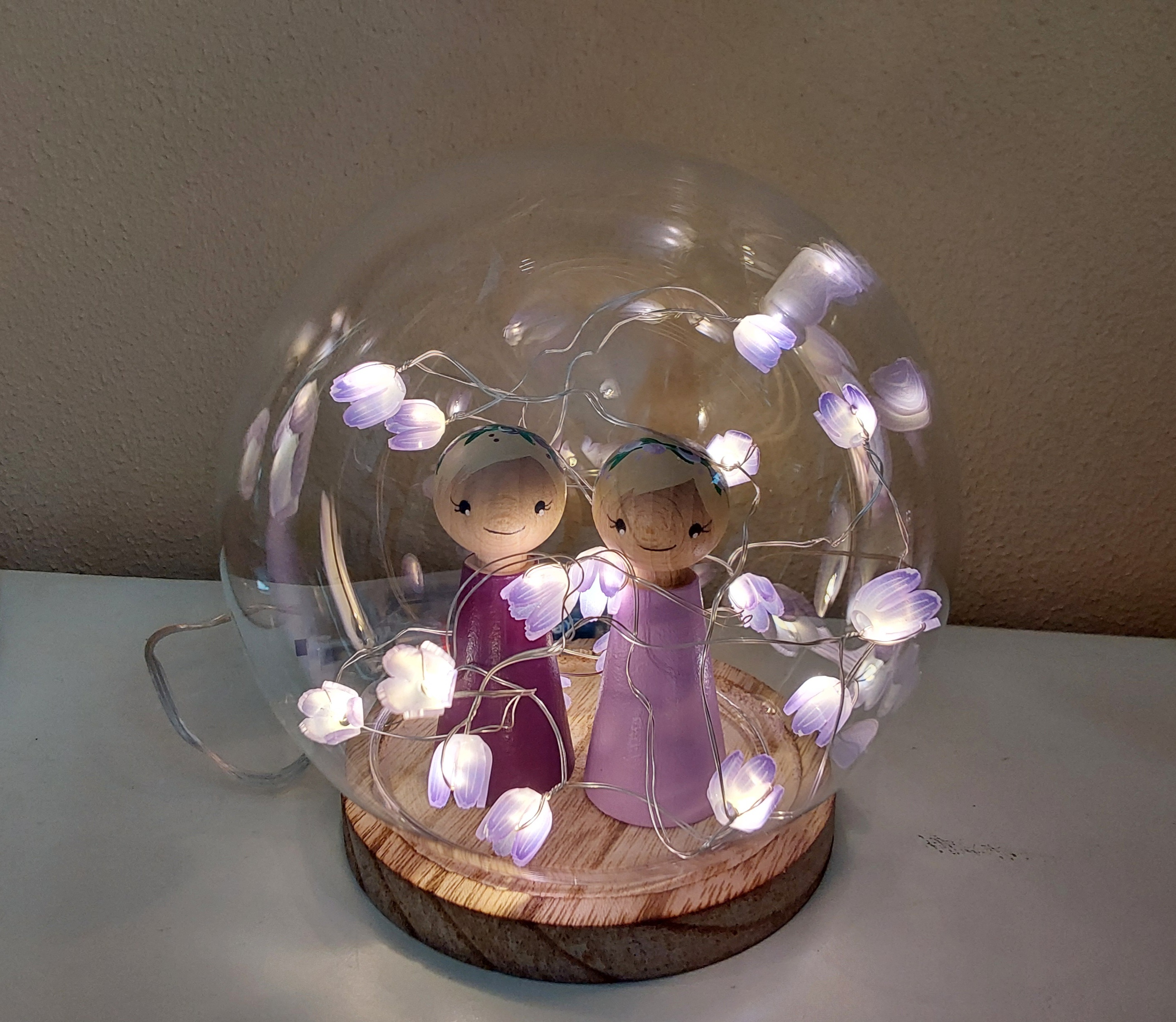 Stolp met paarse verlichte tulpjes en twee bloemenmeisjes