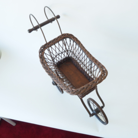 Sierlijke rieten poppenwagen met smeedijzer