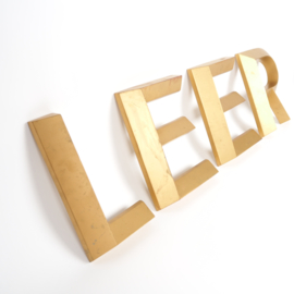 Decoratieve industriële reclameletters in goudkleur: LEER