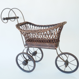 Sierlijke rieten poppenwagen met smeedijzer