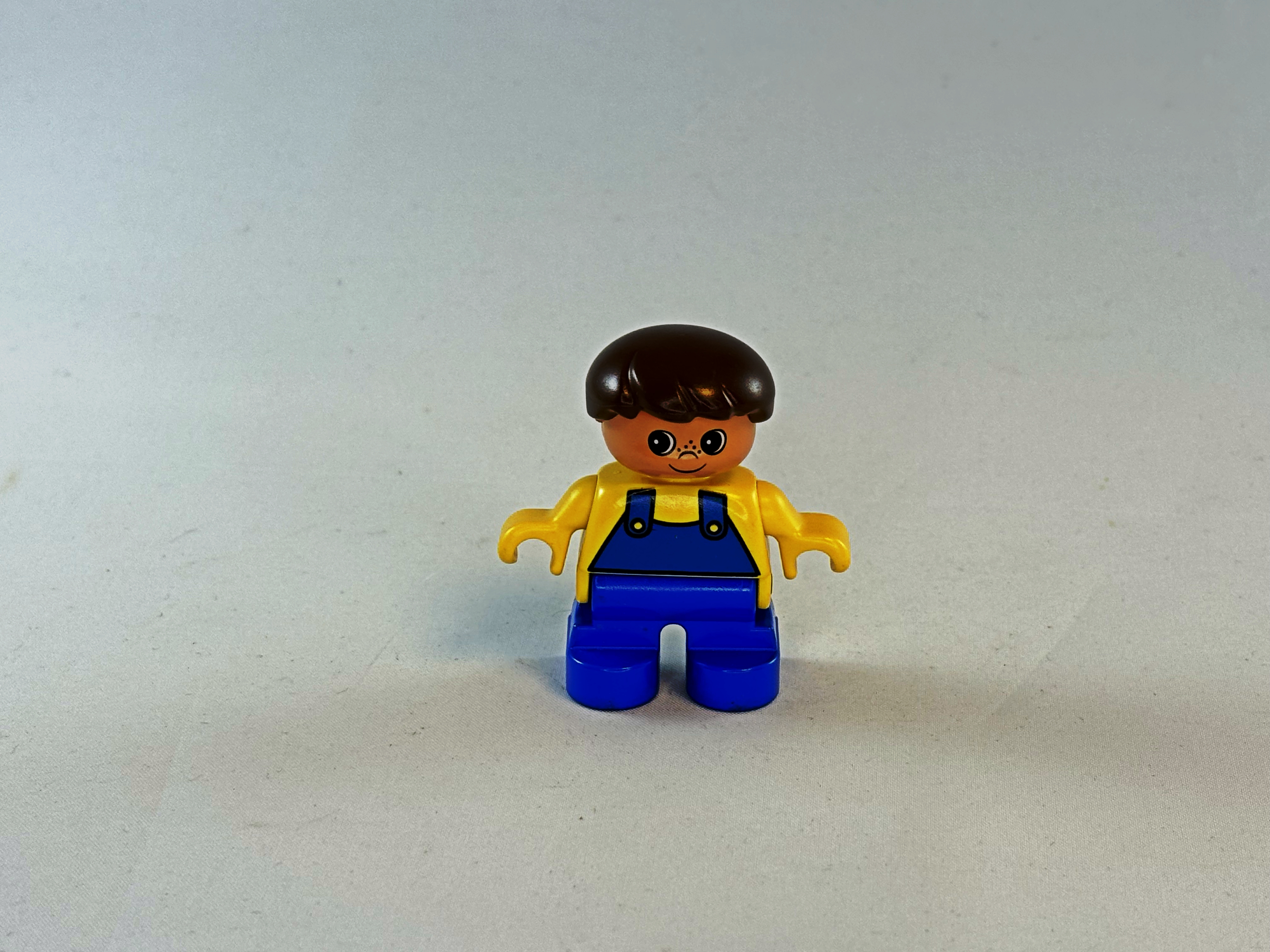 Jongen met tuinbroek blauw geel Duplo