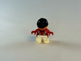 Meisje met rode trui met bloemen, witte broek en cap Duplo