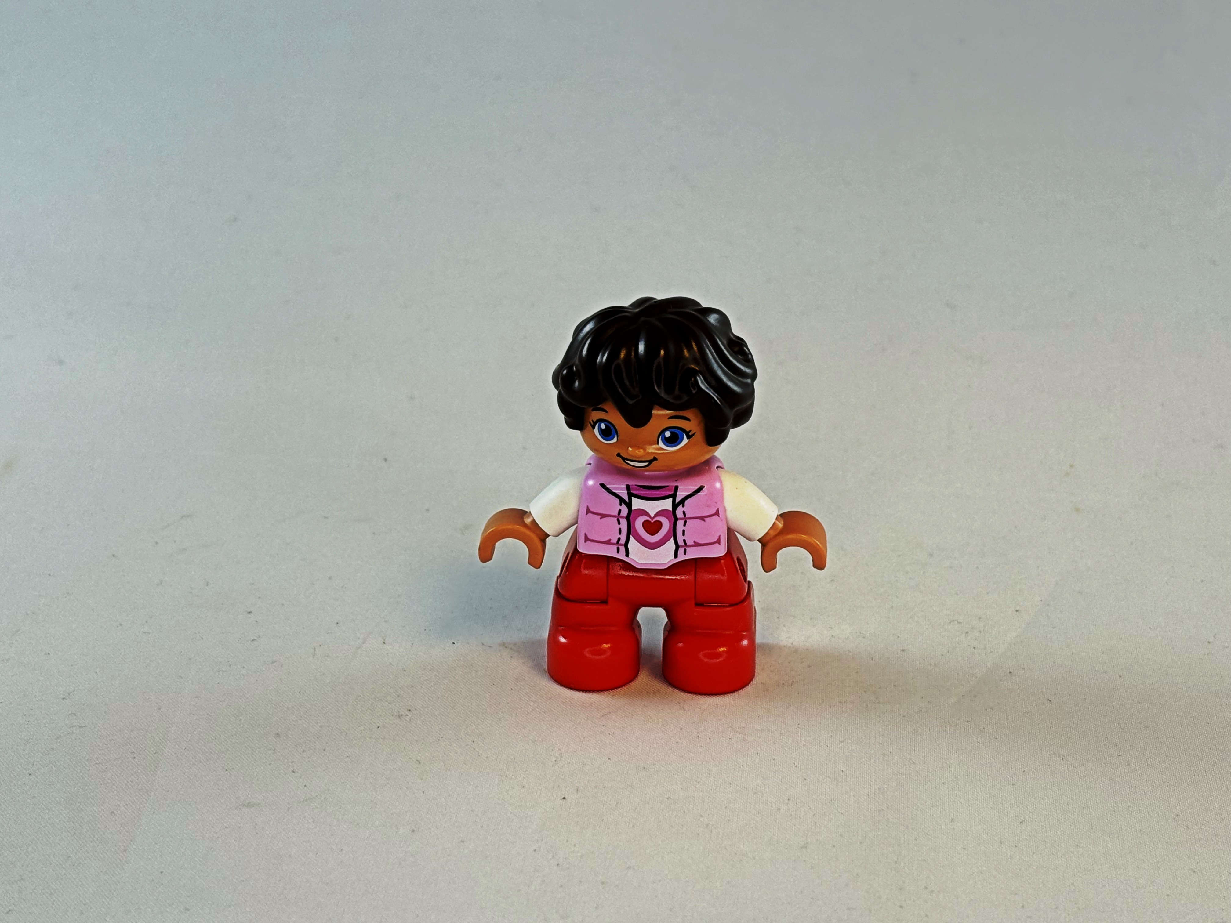 Meisje met rode broek, wit vest met hartje en bruin haar Duplo