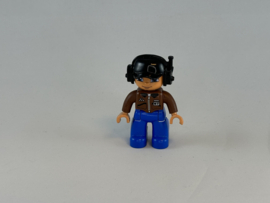 Piloot blauwe broek, bruin vest en zwarte helmDuplo