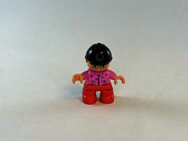 Meisje met rode broek, roze trui en cap Duplo