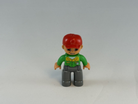 Man met grijze broek, groen overhemd en rode pet Duplo