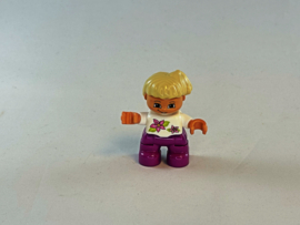 Meisje met paarse broek, wit shirtje bloem en blond haar Duplo