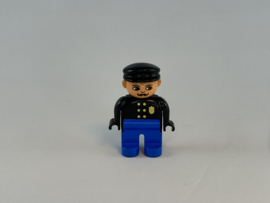 Politieagent met snor blauwe broek, zwarte jas met gouden badge Duplo