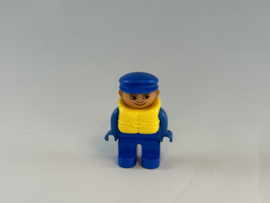Man blauw pak, geel zwemvest en blauwe pet Duplo