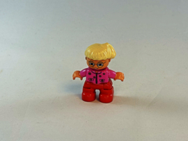 Meisje met rode broek, roze vest, bril en blond haar Duplo