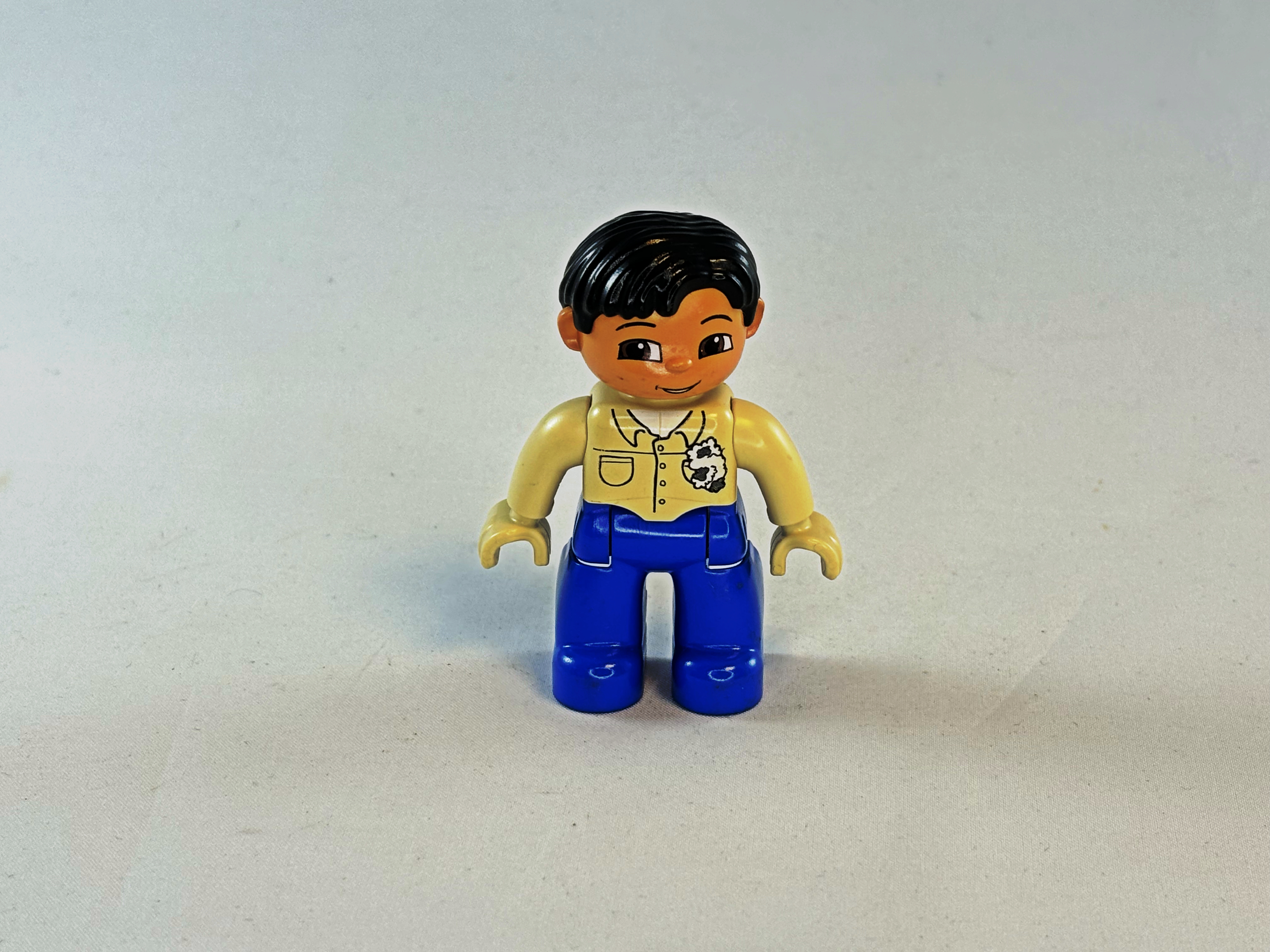 Man met beige overhemd en blauwe broek Duplo