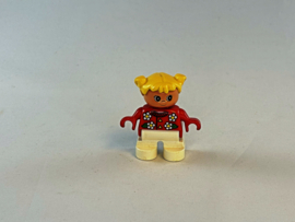 Meisje met witte broek, rode trui met bloemetjes en geel haar Duplo