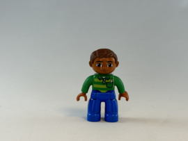 Man licht getint , blauwe broek en groen shirt Duplo
