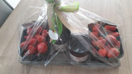 geschenkverpakking: verse aardbeien, huisgemaakte aardbeienconfituur en fles cava