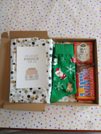 Kerstcadeautje met groene kerstman sokken