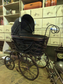Antieke kinderwagen met porselein