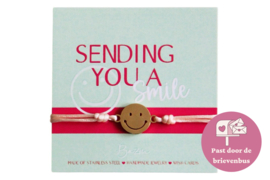 Kaartje met "Sending you a Smile" -  smiley aan een armbandje