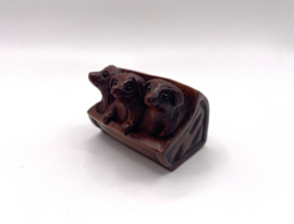 Netsuke van 3 honden in een mandje