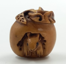 Kleine netsuke van muis in noot