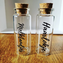 Glazen flesjes haarlokje en melktandje