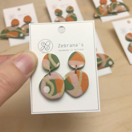 Organische statement oorbellen met abstract patroon in saliegroen, terracotta oranje en oud roze, handgemaakt van klei (met rvs oorstekers)