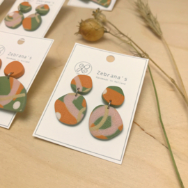 Organische statement oorbellen met abstract patroon in saliegroen, terracotta oranje en oud roze, handgemaakt van klei (met rvs oorstekers)