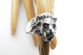 Zilveren leeuwenkop ring met rode ogen en blauw steentje in de bek.