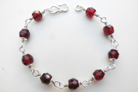 Zilveren bordeaux rode kralen bracelet.