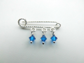 Zilveren baby speld met 3 blauwe ogri ai kraaltjes.