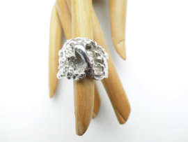 Zilveren rots ring met kleine pantertje erop.