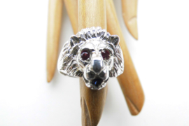 Zilveren leeuwenkop ring met rode ogen en blauw steentje in de bek.