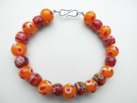 Oranje/rode kralen bracelet met zilveren sluiting.
