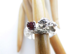 Zilveren ring met leeuwtje en rood steentje.