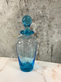 Karaf van blauw glas met geslepen decoratie.