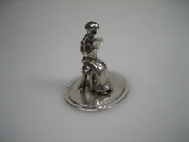 Zilveren miniatuur een dame zittend op haar krukje uit ca. 1980