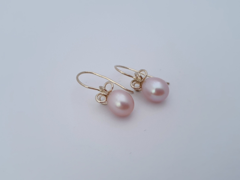 Zilveren oorbellen met roze parel.