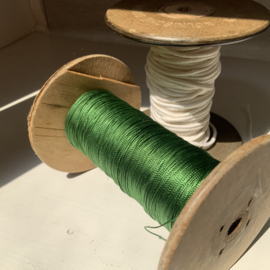 Een klos groen glans garen.