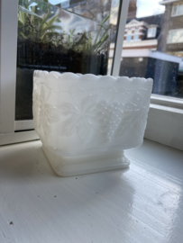 Vintage bloempot op voet van melkglas.