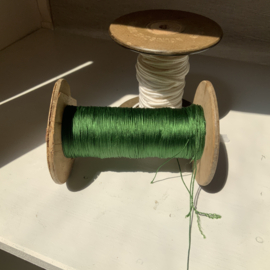 Een klos groen glans garen.